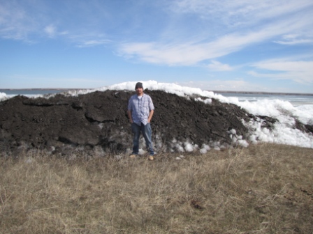 Man standing next to river shoreline erosion